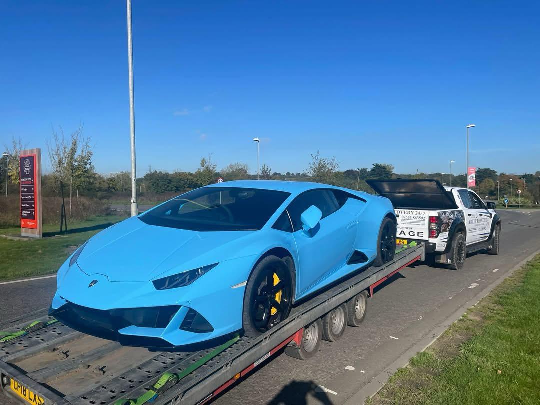 Blue Lamborghini on a vehicle transport trailer